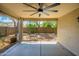 Covered patio includes ceiling fan with view of landscaped backyard and privacy wall at 14237 W Aster Dr, Surprise, AZ 85379