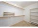 A simple walk-in closet features basic shelving and hanging rods for storage at 14237 W Aster Dr, Surprise, AZ 85379