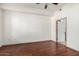 This bedroom features hardwood floors, ceiling fan, and an open doorway to an adjacent room at 14575 W Mountain View Blvd # 12107, Surprise, AZ 85374