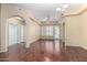 Open living room featuring hardwood floors, arched doorways, and a ceiling fan at 14575 W Mountain View Blvd # 12107, Surprise, AZ 85374