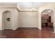 Spacious living room with hardwood floors, arched openings, and a view of the kitchen at 14575 W Mountain View Blvd # 12107, Surprise, AZ 85374