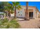 Backyard view featuring desert landscaping, large patio, and the rear of the home under a bright blue sky at 14624 N 90Th Ln, Peoria, AZ 85381