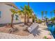 Backyard featuring desert landscaping, palm trees, water feature and the exterior of the home with a blue sky at 14624 N 90Th Ln, Peoria, AZ 85381