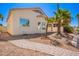 Backyard view with desert landscaping, including palm trees, walkway and the rear of the home under a clear sky at 14624 N 90Th Ln, Peoria, AZ 85381