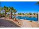 Backyard featuring desert landscaping, palm trees, walkway and a view of the canal under a bright blue sky at 14624 N 90Th Ln, Peoria, AZ 85381