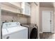 Convenient laundry area equipped with modern washer, dryer, storage, and a door leading to other rooms at 14624 N 90Th Ln, Peoria, AZ 85381