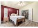 Well-lit main bedroom featuring a queen bed, wood-look floors, and a private sliding glass door to the patio at 14624 N 90Th Ln, Peoria, AZ 85381