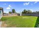 Lush backyard showcasing a well-maintained lawn, secure block fence, and convenient storage shed at 14635 N 37Th Pl, Phoenix, AZ 85032
