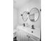Stylish bathroom featuring double sinks, modern fixtures, round mirrors, and elegant vanity lighting at 14635 N 37Th Pl, Phoenix, AZ 85032