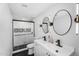 Elegant bathroom with double vanities, modern lighting, and a black and white tiled shower at 14635 N 37Th Pl, Phoenix, AZ 85032