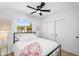 Inviting bedroom with a black-frame bed, fan, and a sunlit window with lush exterior landscape views at 14635 N 37Th Pl, Phoenix, AZ 85032
