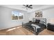 Modern bedroom with a black metal bed frame, ceiling fan, and a view of the backyard at 14635 N 37Th Pl, Phoenix, AZ 85032