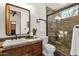 Updated bathroom featuring dark wood vanity, framed mirror, walk-in shower with tile surround at 14760 E Paradise Dr, Fountain Hills, AZ 85268