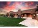 Expansive backyard with lush lawn and a covered patio featuring an outdoor fireplace, perfect for entertaining at 14760 E Paradise Dr, Fountain Hills, AZ 85268