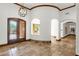 Inviting foyer featuring arched doorways, travertine flooring, and wrought iron double doors at 14760 E Paradise Dr, Fountain Hills, AZ 85268