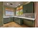 Well-lit kitchen featuring green cabinets, granite countertops, and a charming window with picturesque views at 14760 E Paradise Dr, Fountain Hills, AZ 85268