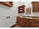 Functional laundry room boasts wooden cabinets, granite countertops, and ample storage space at 14760 E Paradise Dr, Fountain Hills, AZ 85268