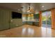 Inviting living room with wood floors, a ceiling fan, and green cabinets by the wet bar at 14760 E Paradise Dr, Fountain Hills, AZ 85268