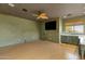 Inviting living room with wood floors, a ceiling fan, and green cabinets by the wet bar at 14760 E Paradise Dr, Fountain Hills, AZ 85268