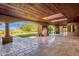 Spacious covered patio with travertine tiles, stone fireplace and lush backyard views at 14760 E Paradise Dr, Fountain Hills, AZ 85268