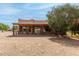 Rear exterior with covered patio, railing, and a spacious backyard with desert landscaping at 16222 W Augusta Ave, Litchfield Park, AZ 85340