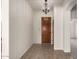 Welcoming entryway with tiled floor, a decorative light, and wooden door at 16222 W Augusta Ave, Litchfield Park, AZ 85340
