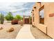 Tan single-Gathering home with desert landscaping along the walkway and native shrubs at 16222 W Augusta Ave, Litchfield Park, AZ 85340
