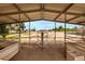 Interior view of a horse shelter with metal beams, multiple stalls and access to the horse area at 16222 W Augusta Ave, Litchfield Park, AZ 85340