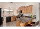 A well-lit kitchen is showcased with light wood cabinets and a granite countertop island and breakfast bar at 16222 W Augusta Ave, Litchfield Park, AZ 85340