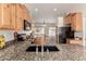 Well-equipped kitchen boasting granite countertops and wood cabinetry with an open concept design at 16222 W Augusta Ave, Litchfield Park, AZ 85340