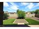 Backyard view features an artificial turf area, gravel landscaping, and desert plants at 16418 W Whitehorn Way, Surprise, AZ 85387
