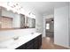 Bathroom offering dual sinks, vanity, mirrors, and a passage to the bedroom at 16418 W Whitehorn Way, Surprise, AZ 85387