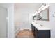 Bathroom showcasing dual sinks, vanity, and a door to the shower-tub combination at 16418 W Whitehorn Way, Surprise, AZ 85387