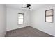 Cozy bedroom with neutral carpet, two windows with blinds, and ceiling fan at 16418 W Whitehorn Way, Surprise, AZ 85387