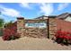Community sign in stone reads 'Santofina at Desert Oasis' with flower bushes at 16418 W Whitehorn Way, Surprise, AZ 85387