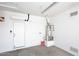 Spotless garage featuring a water heater and wall-mounted mini-split air conditioner at 16418 W Whitehorn Way, Surprise, AZ 85387