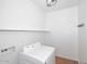Bright laundry room featuring modern Samsung washer, shelf, and tiled floor at 16418 W Whitehorn Way, Surprise, AZ 85387