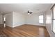Bright living room featuring hardwood floors, ceiling fan, and natural light at 16418 W Whitehorn Way, Surprise, AZ 85387