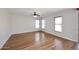 Open living room with hardwood floors, windows with blinds, and ceiling fan at 16418 W Whitehorn Way, Surprise, AZ 85387