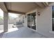 Covered patio with sliding glass doors, wall-mounted lights, and low maintenance gravel landscaping at 16418 W Whitehorn Way, Surprise, AZ 85387