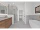 Bright bathroom with standalone soaking tub, dual vanity, and glass enclosed shower at 19550 N Grayhawk Dr # 1039, Scottsdale, AZ 85255