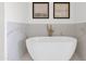 Close up of a modern, oval soaking tub with elegant fixtures and marble surround at 19550 N Grayhawk Dr # 1039, Scottsdale, AZ 85255