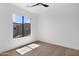 Sunlit bedroom with wood floors, bright walls, and neighborhood views from the window at 19550 N Grayhawk Dr # 1039, Scottsdale, AZ 85255