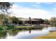 Scenic view of pond with clubhouse in the background, landscaped with mature trees and well-maintained greenery at 19550 N Grayhawk Dr # 1039, Scottsdale, AZ 85255
