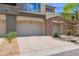 Attached two-car garage with stone accents and driveway at 19550 N Grayhawk Dr # 1039, Scottsdale, AZ 85255