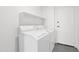 Bright laundry room features a washing machine, dryer, and shelving at 19550 N Grayhawk Dr # 1039, Scottsdale, AZ 85255