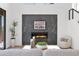 Contemporary living room features a sleek fireplace with stone surround, a plush armchair, and modern decor at 19550 N Grayhawk Dr # 1039, Scottsdale, AZ 85255