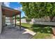 A covered patio overlooks the grassy backyard with a pool, shaded by a mature tree at 19920 N 69Th Ave, Glendale, AZ 85308