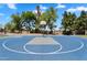 A bright blue and gray basketball court with a hoop surrounded by trees and benches at 19920 N 69Th Ave, Glendale, AZ 85308