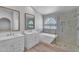 This luxurious bathroom offers double sinks, a soaking tub, and a glass-enclosed shower at 19920 N 69Th Ave, Glendale, AZ 85308